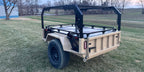 Tan Slack Wagon trailer with modular rack, rear three-quarter view at dusk